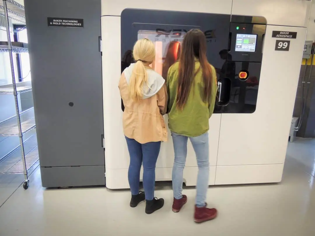 Students observing an FDM 3D printer while on a tour at Baker Industries for Manufacturing Day 2016